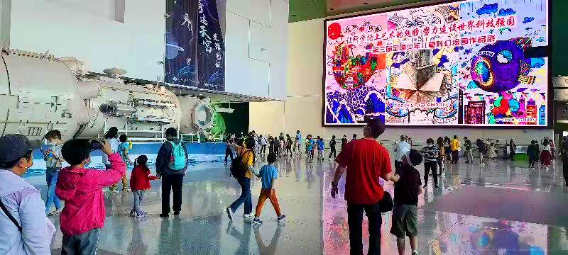 中国科技馆展览大厅电子屏前作者们在拍照